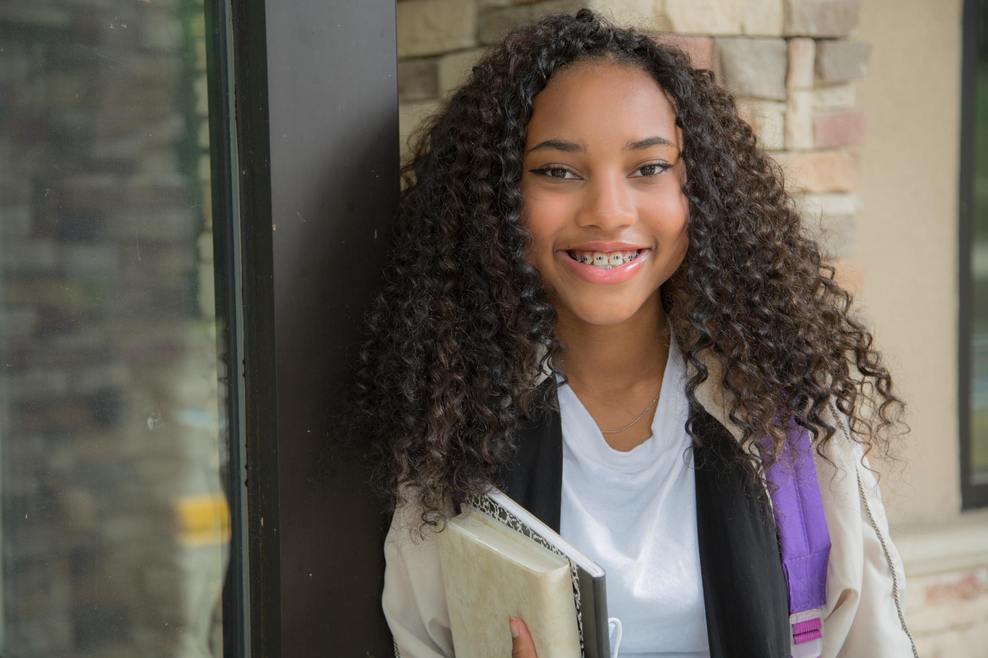 Girl with braces wearing a backpack on her way to school