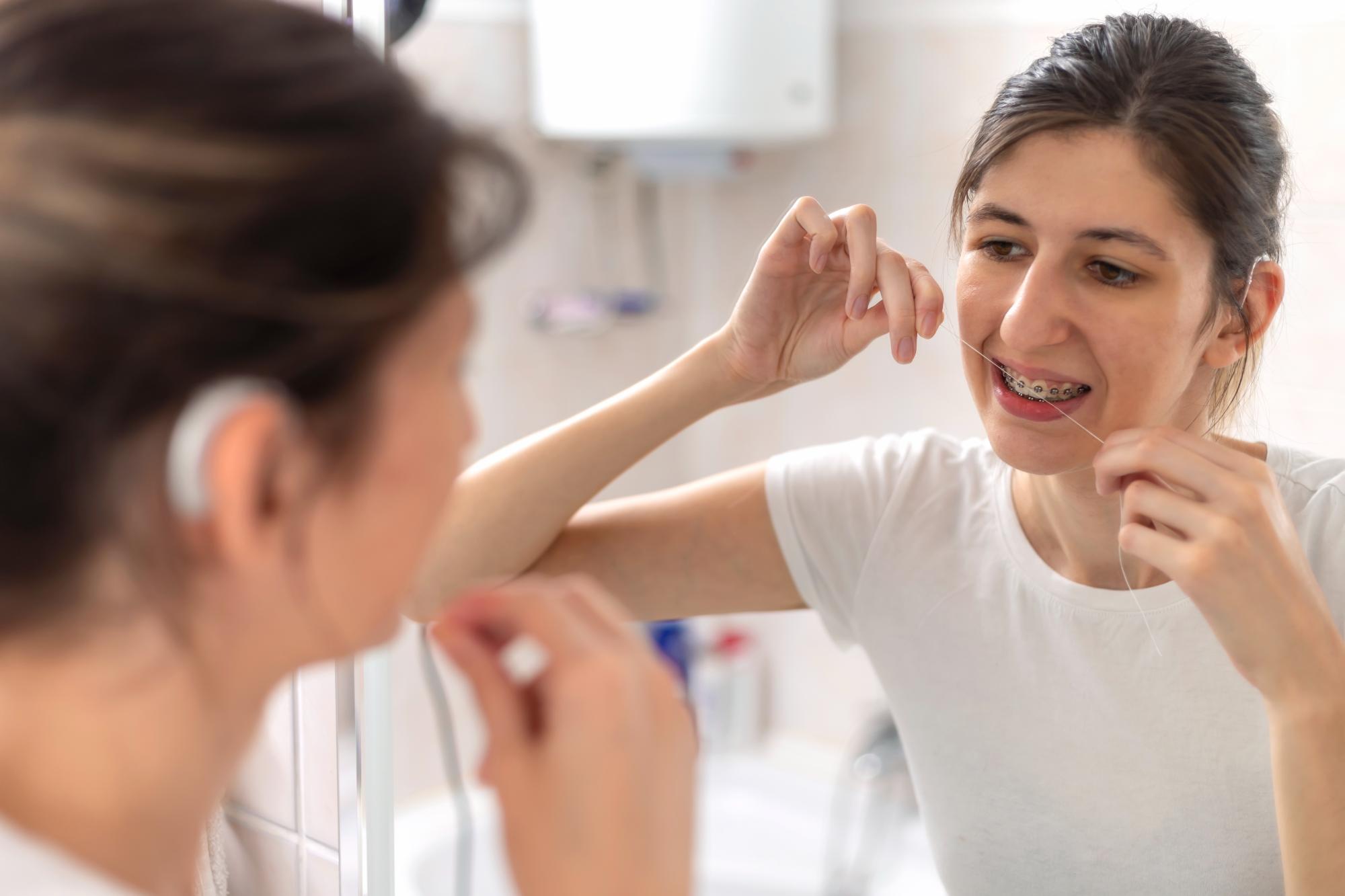 Person flossing between teeth for oral hygiene