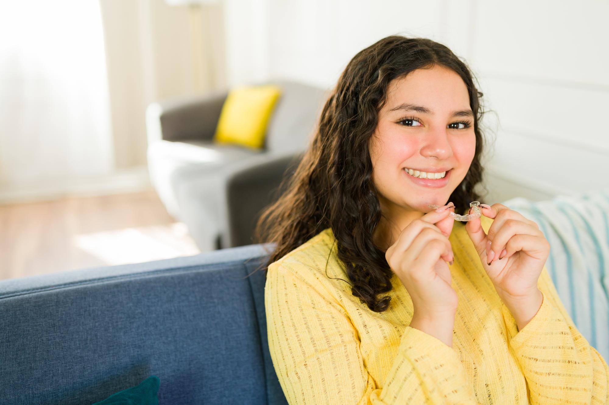 Teen girl holding a clear aligner tray
