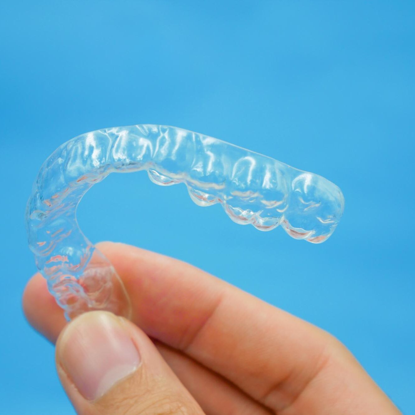 Person holding a clear aligner tray